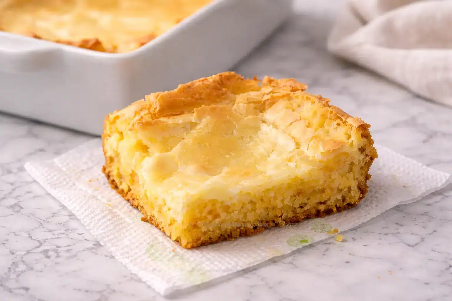 Gluten-Free French Butter Cake 2 Gluten-Free French Butter Cake with a creamy cream cheese layer and buttery golden base, sliced and served on a marble surface