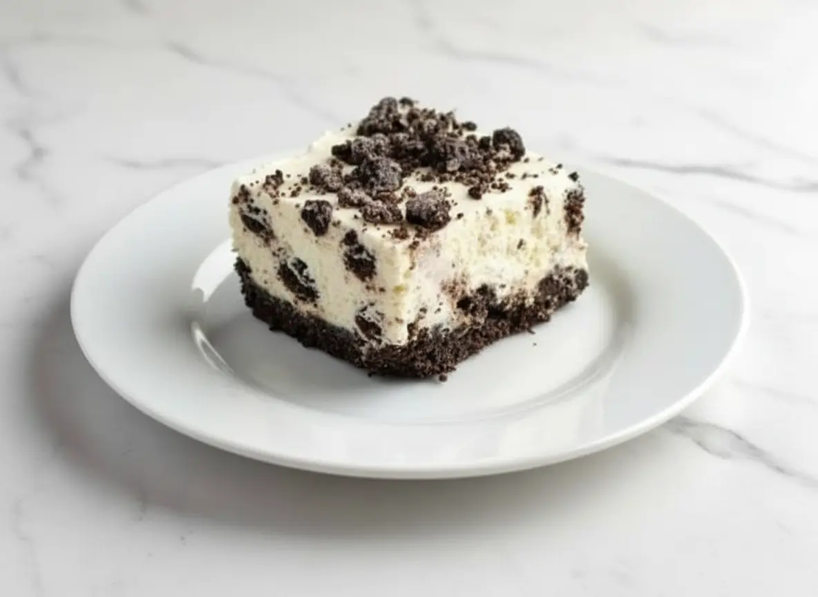 Slice of No Bake Oreo Cheesecake with cookie crust on a white plate.