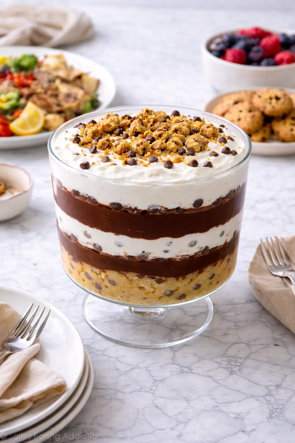 Cookie dough trifle with layers of edible cookie dough, chocolate pudding, and whipped cream in a glass bowl
