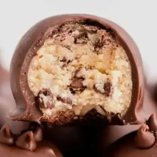 Cookie dough truffles coated in chocolate with a soft cookie dough center, ready to serve