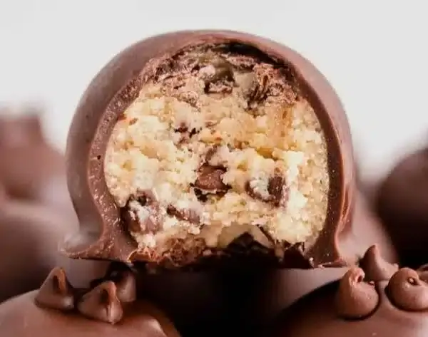 Cookie dough truffles coated in chocolate with a soft cookie dough center, ready to serve