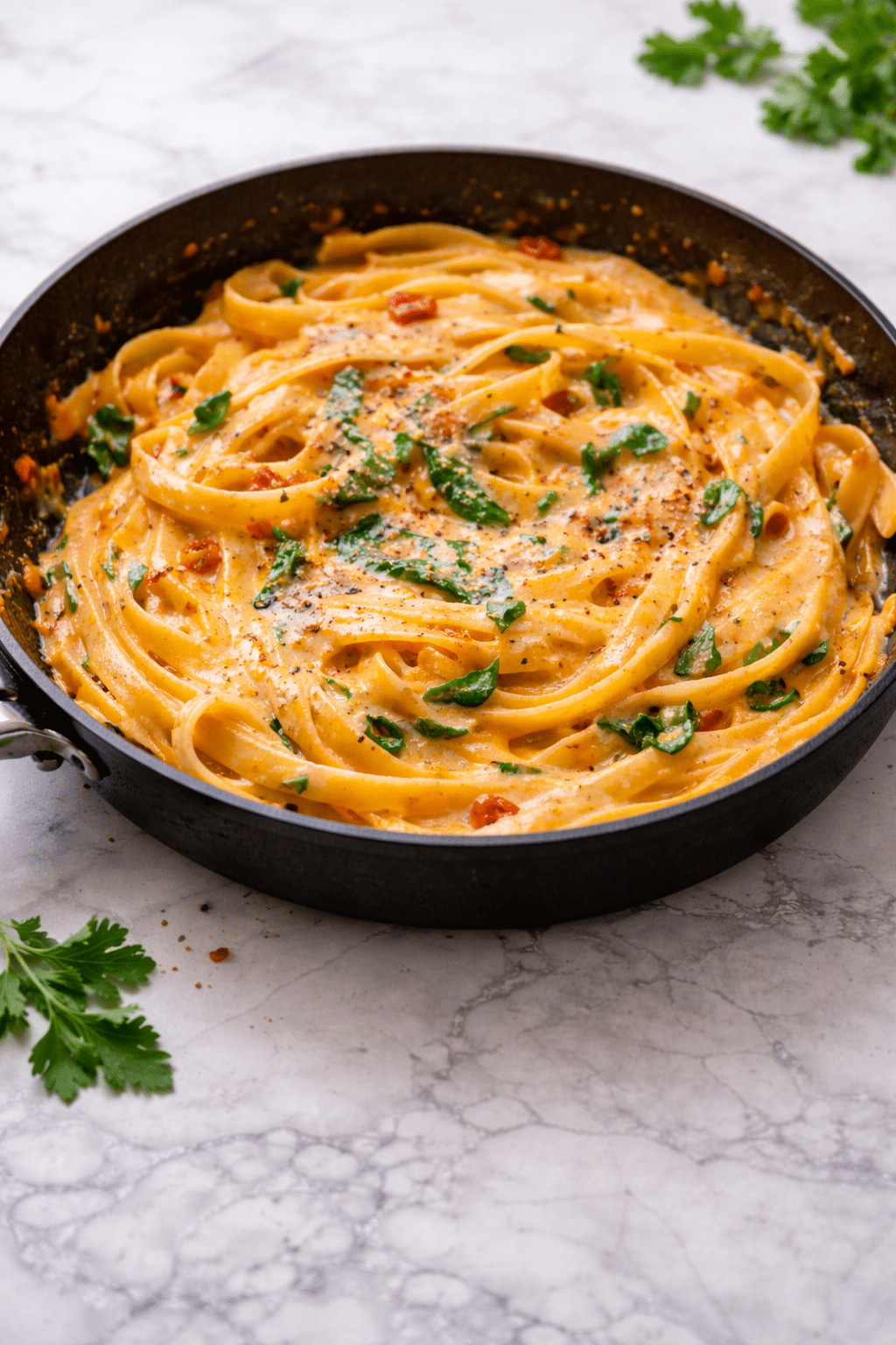 Vegan Creamy Sun Dried Tomato Pasta cooked in a skillet with a smooth, creamy sauce