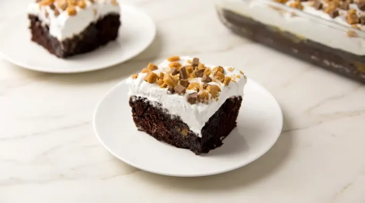 Photorealistic Better Than Sex Cake, ready to serve, on white marble. Overhead, 16x9. Naturally plated, rich and decadent dessert.