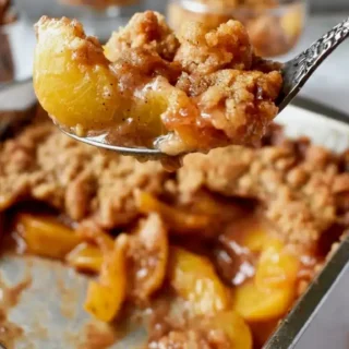Homemade Fresh Peach Crisp Recipe Homemade Fresh Peach Crisp Recipe, photorealistic and freshly cooked, naturally plated and ready to serve on white marble.