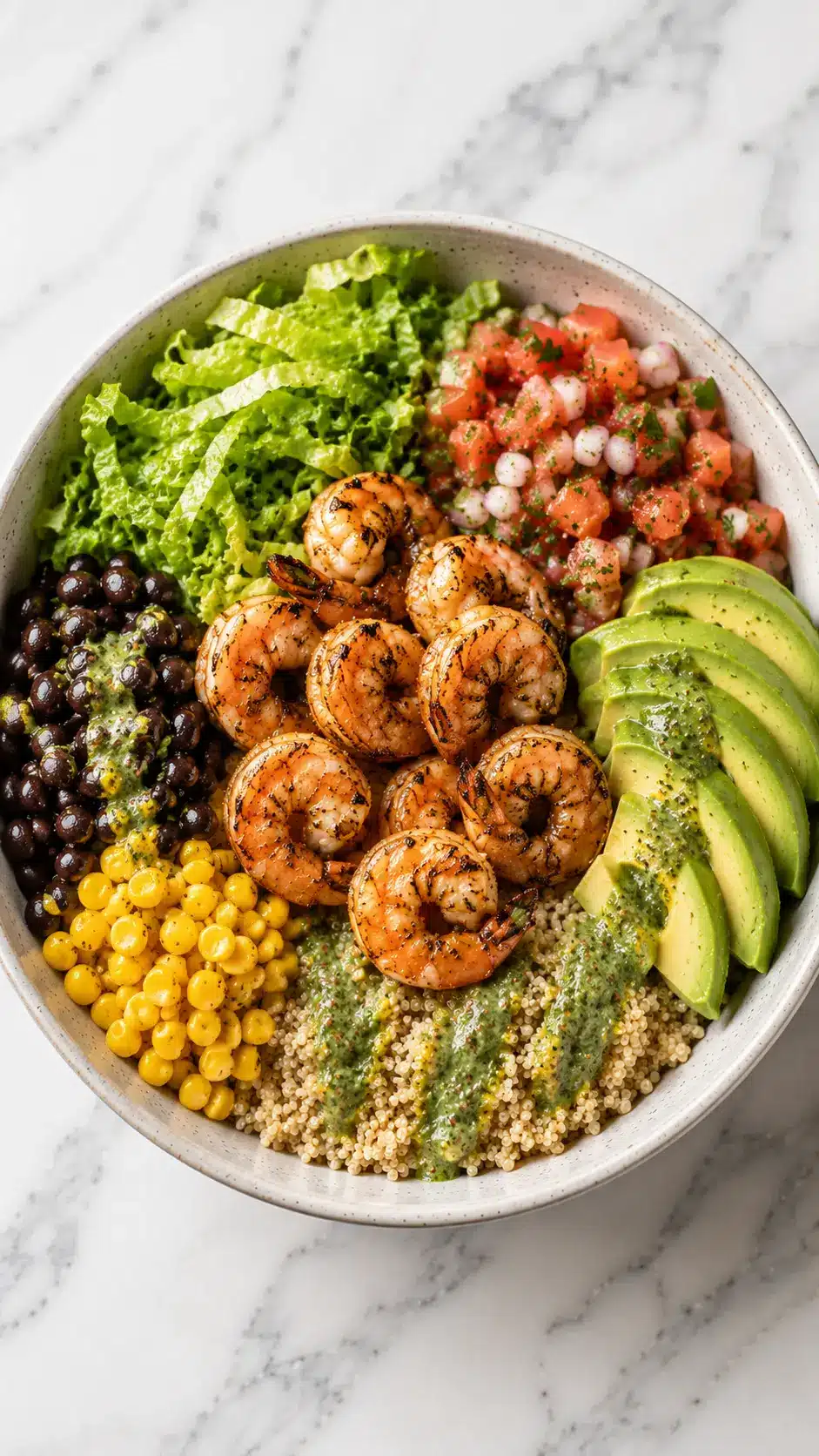Healthy Shrimp Avocado Bowls Healthy Shrimp Avocado Bowls with grilled shrimp, quinoa, sliced avocado, black beans, corn, romaine lettuce, pico de gallo, and cilantro vinaigrette in a ceramic bowl.