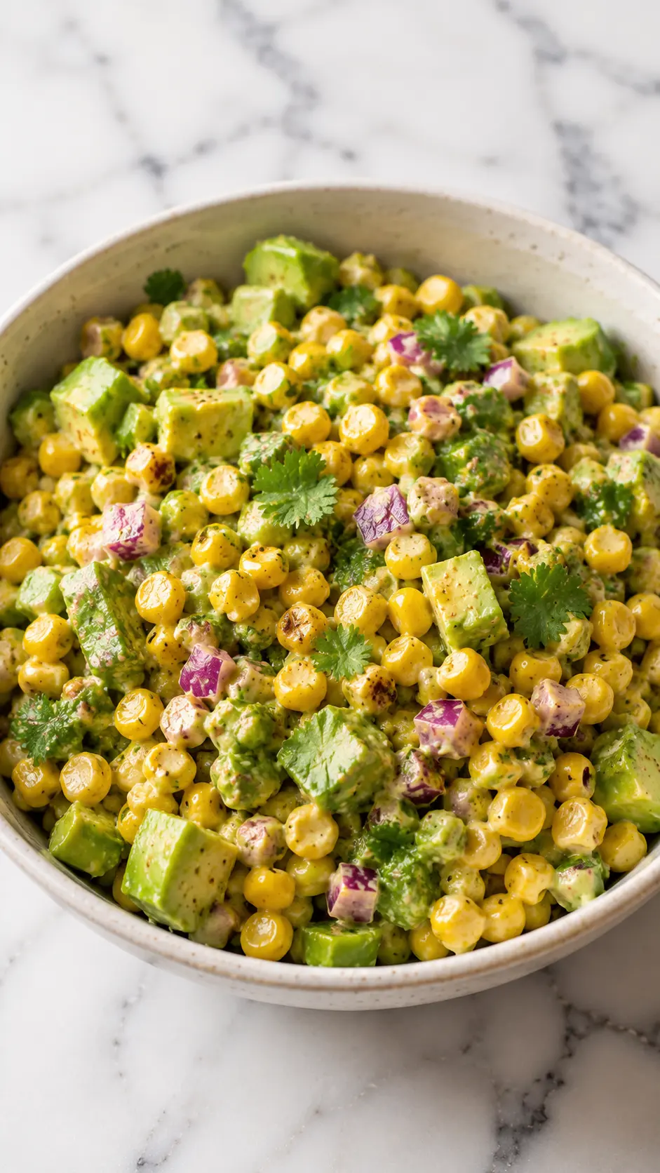 Tomatillo corn salad Vertical 9:16 photo of Tomatillo corn salad with grilled corn, tomatillos, red onion, cilantro, and creamy avocado dressing in a ceramic bowl.